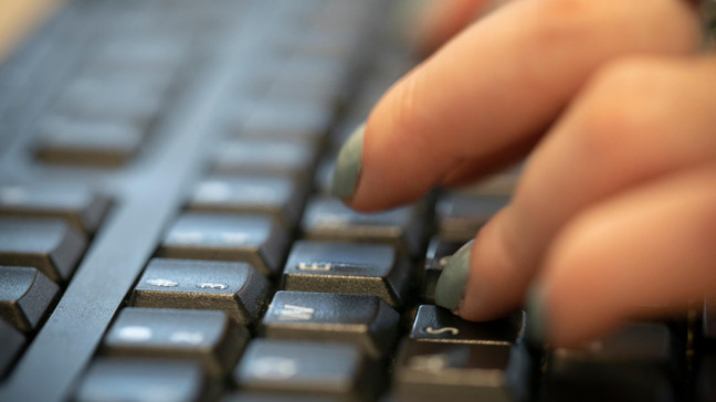 FILE - In this Oct. 8, 2019, file photo a woman types on a keyboard in New York. (AP Photo/Jenny Kane, File)