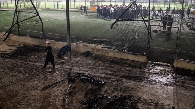 A boy walks past bicycles left next to the area that was hit by a rocket, killing multiple children and teenagers, on a soccer field in the Druze town of Majdal Shams, in the Israeli-annexed Golan Heights, Saturday, July 27, 2024. (AP Photo/Leo Correa)