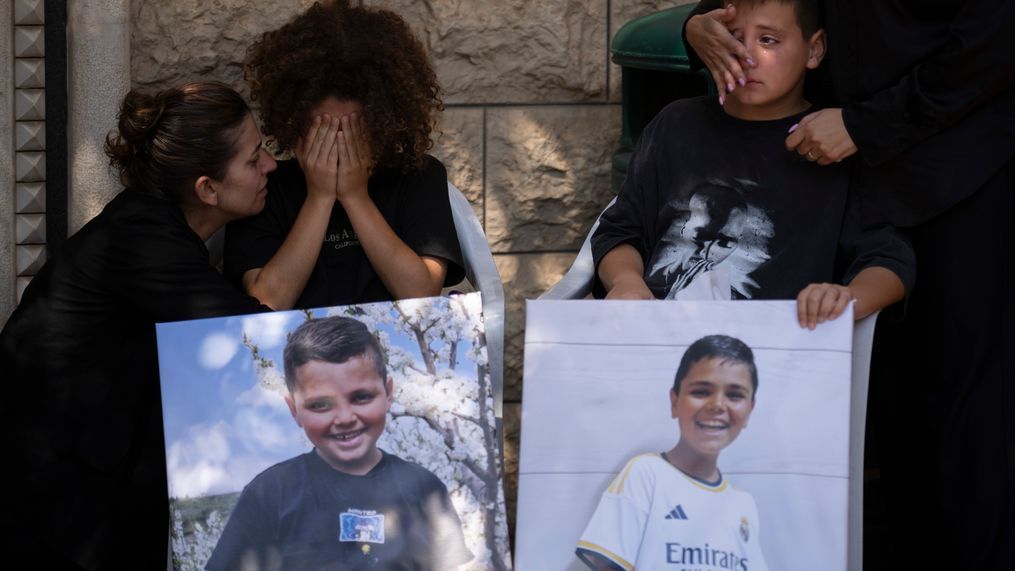 Mourners from the Druze minority weep during the funeral for Guevara Ibrahim, 11, one of 12 children and teens killed in a rocket strike on a soccer field, in the village of Majdal Shams, in the Israeli-annexed Golan Heights, Monday, July 29, 2024. (AP Photo/Leo Correa)