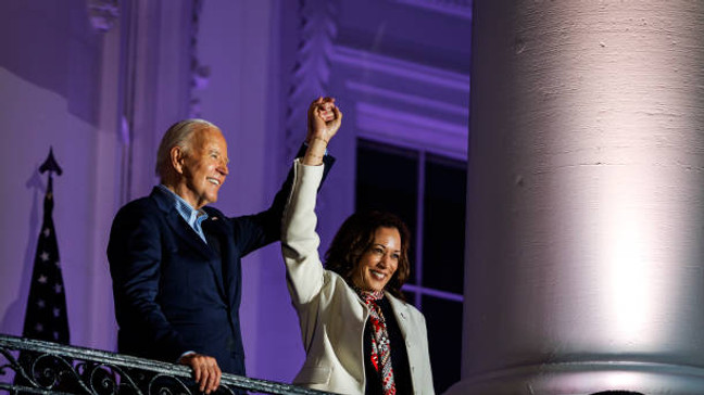 WASHINGTON, DC - JULY 04: President Joe Biden and Vice President Kamala Harris join hands in the air after watching the fireworks on the National Mall with First Lady Jill Biden and Second Gentleman Doug Emhoff from the White House balcony during a 4th of July event on the South Lawn of the White House on July 4, 2024 in Washington, DC. The President is hosting the Independence Day event for members of the military and their families. (Photo by Samuel Corum/Getty Images)